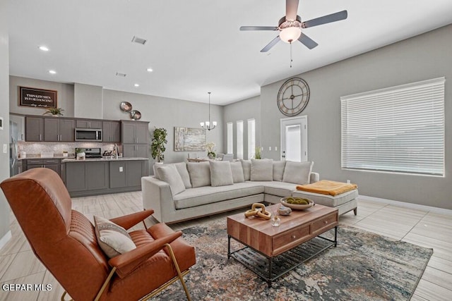 living area featuring baseboards, ceiling fan with notable chandelier, recessed lighting, and visible vents
