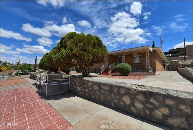 ranch-style home with brick siding, fence, and a gate