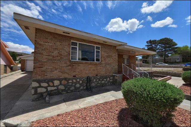 single story home featuring crawl space, a garage, and brick siding