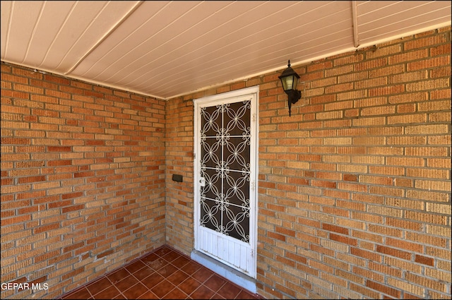 doorway to property with brick siding