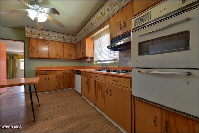 kitchen featuring a sink, a warming drawer, white dishwasher, a ceiling fan, and under cabinet range hood