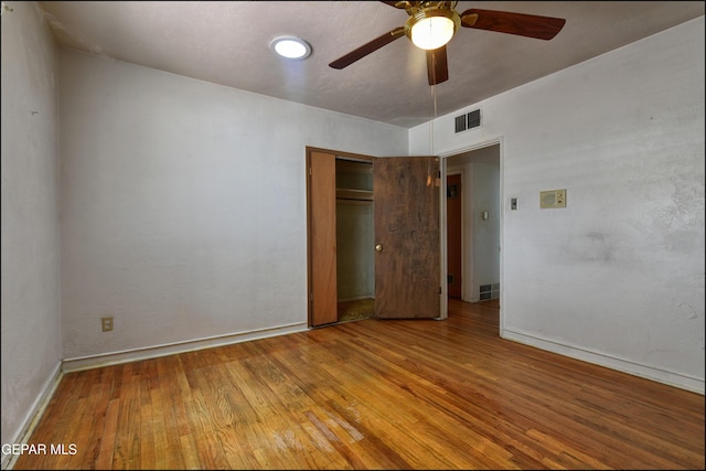 unfurnished bedroom with wood finished floors, baseboards, a closet, and ceiling fan