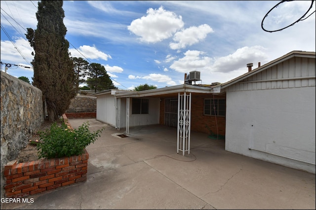rear view of property with a patio, central AC unit, and fence