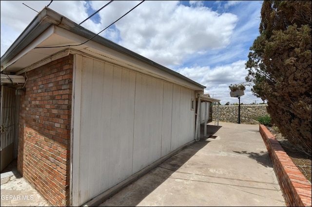 view of side of home featuring a patio area and brick siding