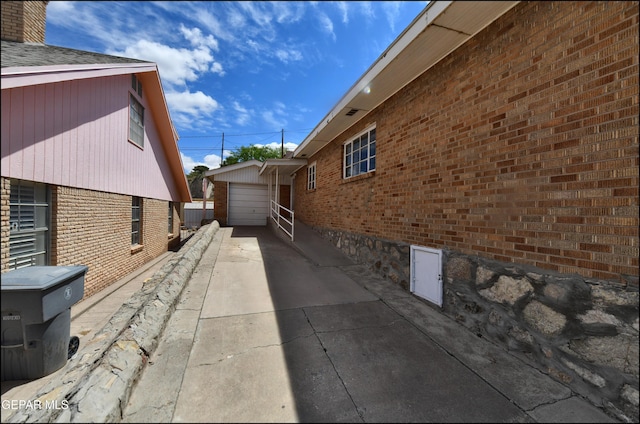 view of home's exterior with concrete driveway, brick siding, and a garage