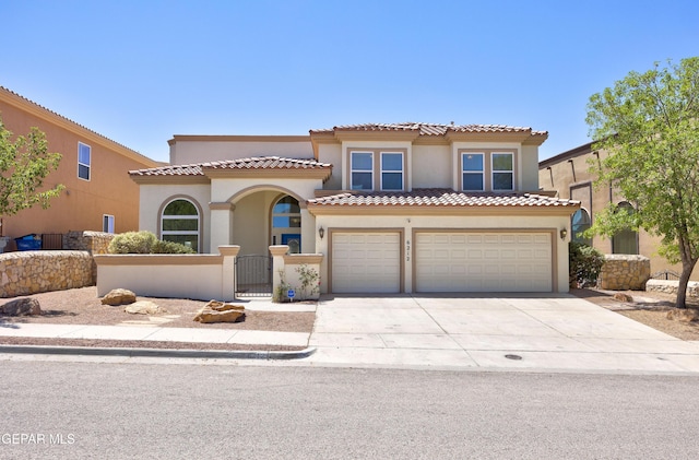 mediterranean / spanish home with driveway, a fenced front yard, a tile roof, a garage, and stucco siding