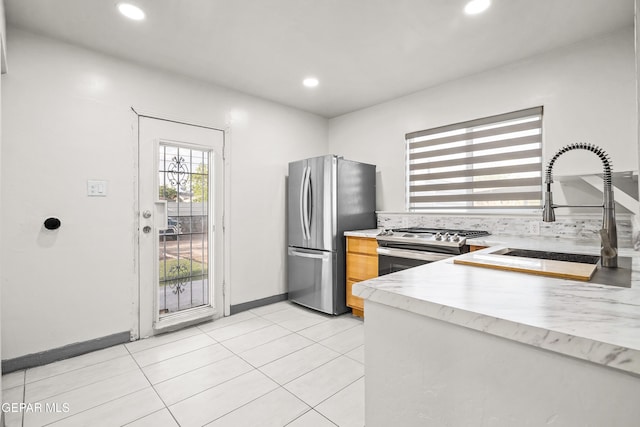 kitchen with recessed lighting, stainless steel appliances, light tile patterned flooring, a sink, and light countertops