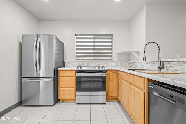 kitchen with a sink, stainless steel appliances, decorative backsplash, and light tile patterned floors