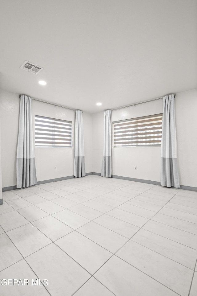 empty room featuring visible vents, baseboards, and recessed lighting