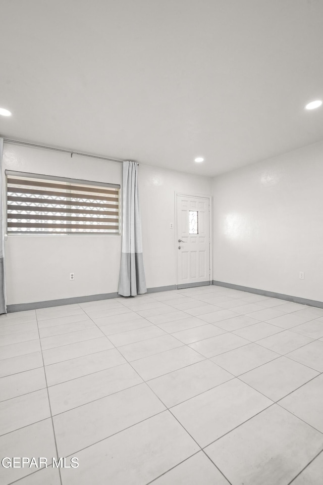 unfurnished room with light tile patterned floors, baseboards, and recessed lighting