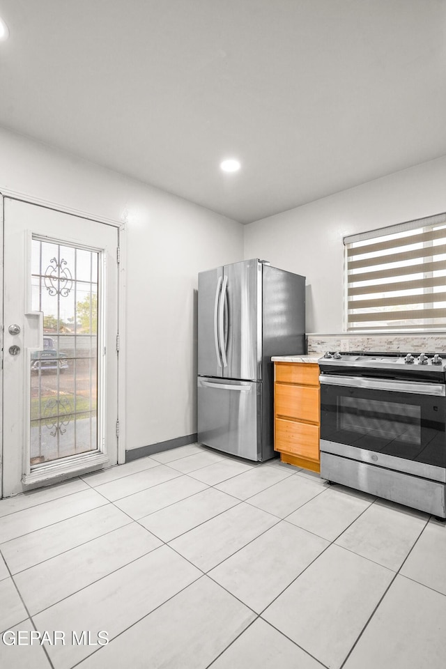 kitchen with light tile patterned floors, recessed lighting, light countertops, and appliances with stainless steel finishes