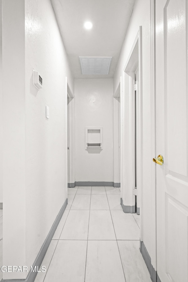 hall featuring baseboards, light tile patterned floors, visible vents, and recessed lighting