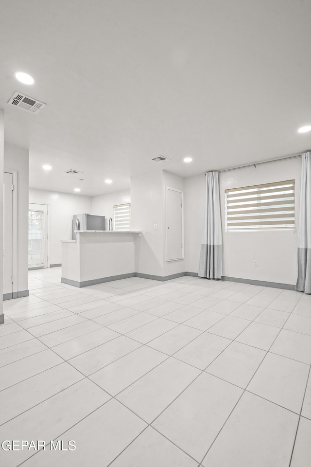 unfurnished living room with baseboards, visible vents, and recessed lighting