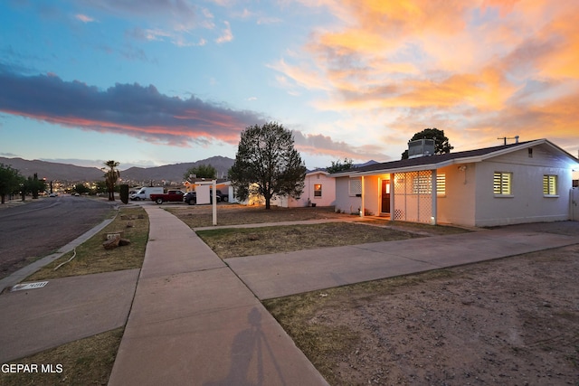 view of front of property with concrete driveway, stucco siding, and a mountain view