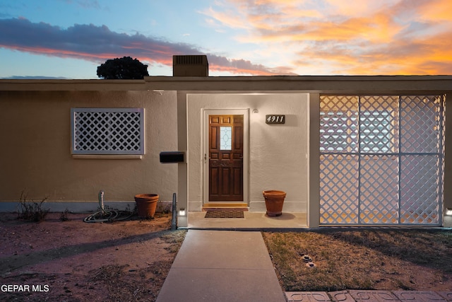 exterior entry at dusk with stucco siding