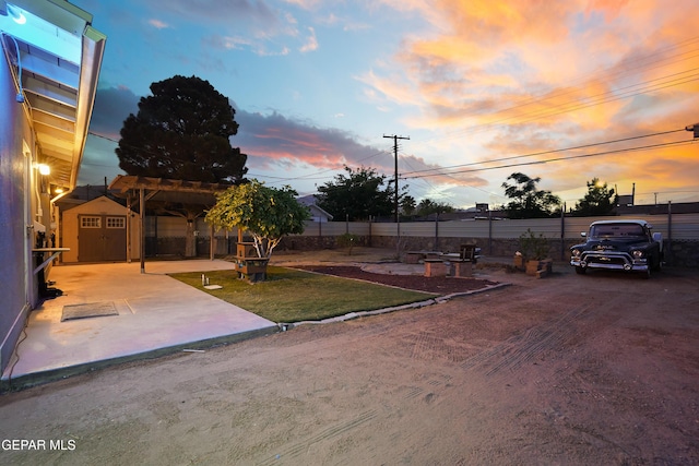 view of yard featuring an outdoor structure, a storage shed, and fence
