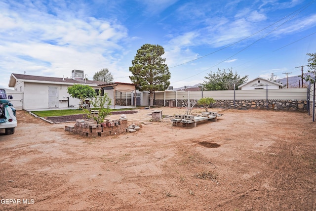 view of yard featuring fence and central AC