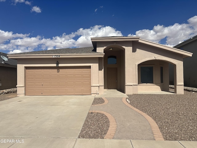 view of front facade featuring stucco siding, driveway, and a garage