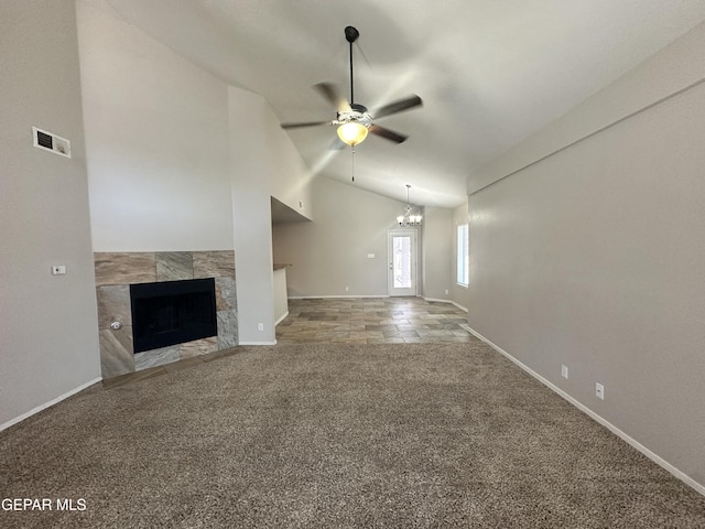 unfurnished living room featuring a ceiling fan, carpet flooring, a tile fireplace, a chandelier, and baseboards