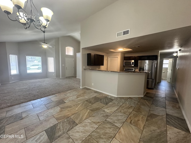 kitchen with stainless steel appliances, high vaulted ceiling, a chandelier, and baseboards
