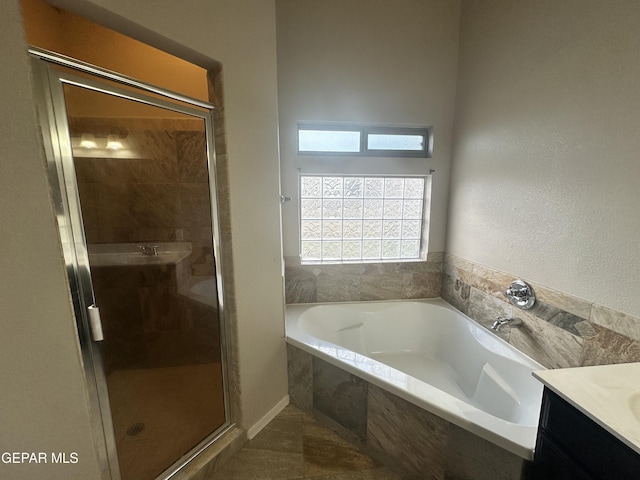 bathroom featuring a garden tub, a shower stall, and vanity