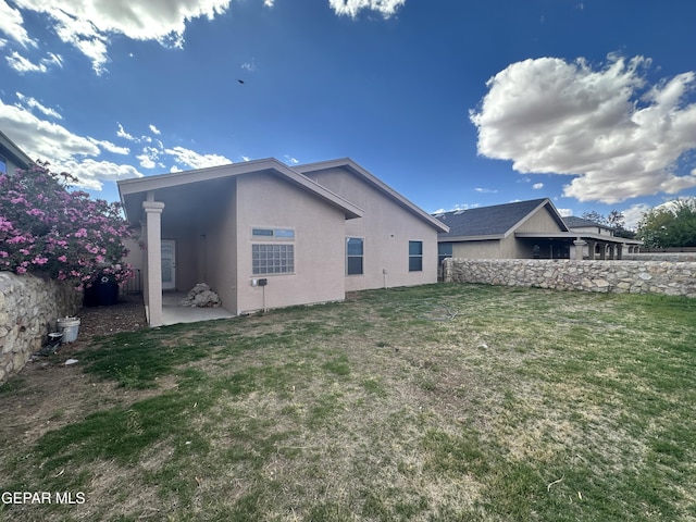 back of property with stucco siding and a patio