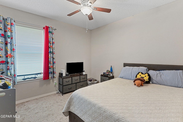 carpeted bedroom featuring a textured ceiling, baseboards, and ceiling fan