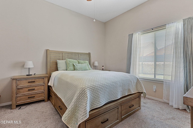bedroom with baseboards and light carpet