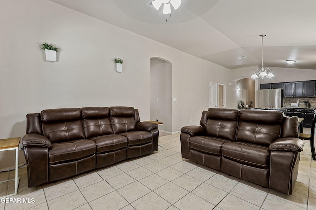 living room featuring arched walkways, light tile patterned floors, lofted ceiling, and ceiling fan with notable chandelier