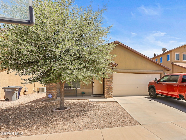 view of front of house with a garage, stone siding, stucco siding, central AC unit, and concrete driveway