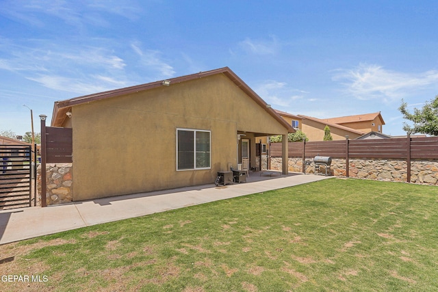 back of house featuring fence, a patio, stucco siding, and a yard