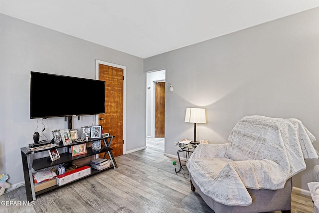 living area with baseboards and wood finished floors