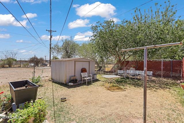 view of yard with an outdoor structure, a fenced backyard, and a storage unit