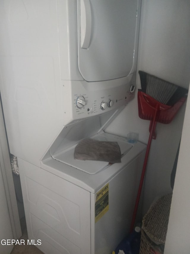 clothes washing area featuring stacked washer and clothes dryer