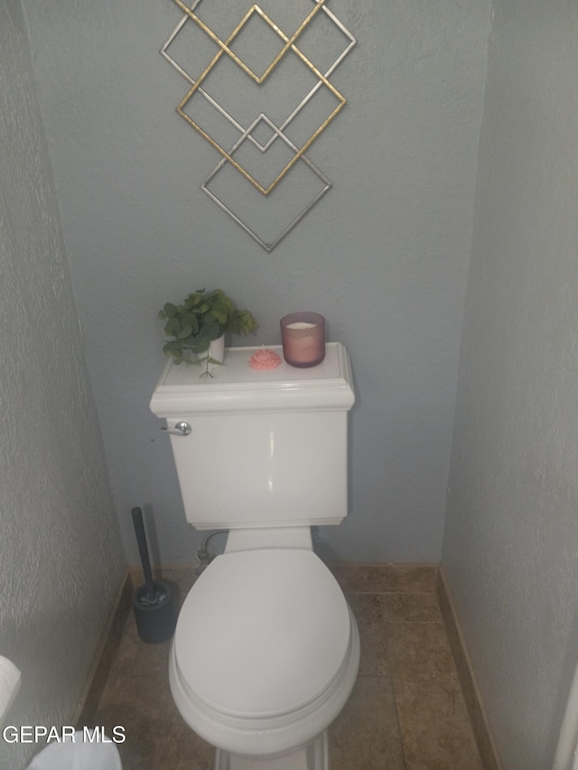 bathroom featuring toilet, tile patterned flooring, and baseboards