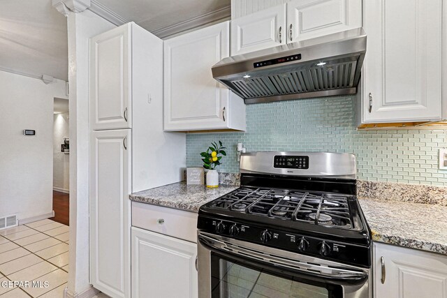 kitchen with gas range, white cabinetry, light tile patterned floors, range hood, and tasteful backsplash