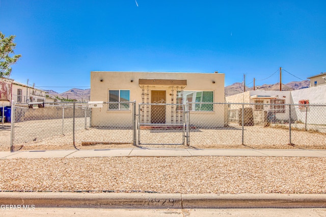 8929 Robert Dr Unit 1 & 2, El Paso, TX 79904 - adobe home with a mountain view, a fenced front yard, a gate, and stucco siding