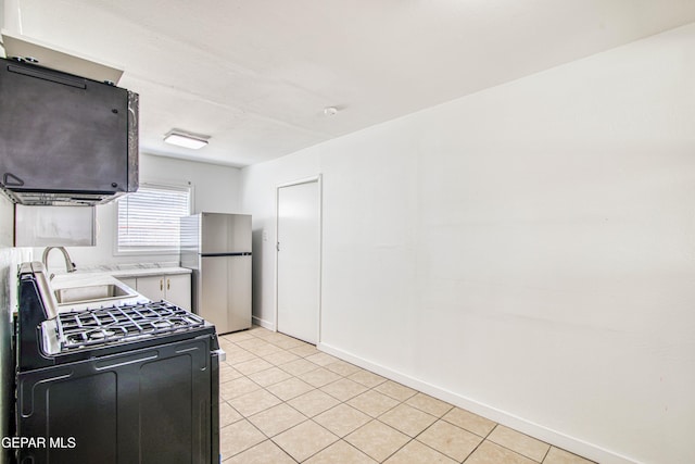 8929 Robert Dr Unit 1 & 2, El Paso, TX 79904 - kitchen featuring a sink, baseboards, light tile patterned floors, freestanding refrigerator, and black gas range