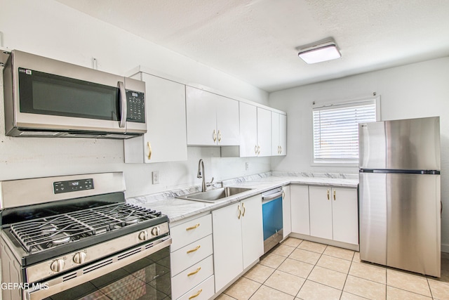 8929 Robert Dr Unit 1 & 2, El Paso, TX 79904 - kitchen with a sink, light countertops, white cabinets, stainless steel appliances, and light tile patterned flooring