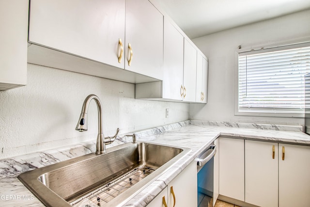 8929 Robert Dr Unit 1 & 2, El Paso, TX 79904 - kitchen with light stone counters, a sink, dishwasher, and white cabinets