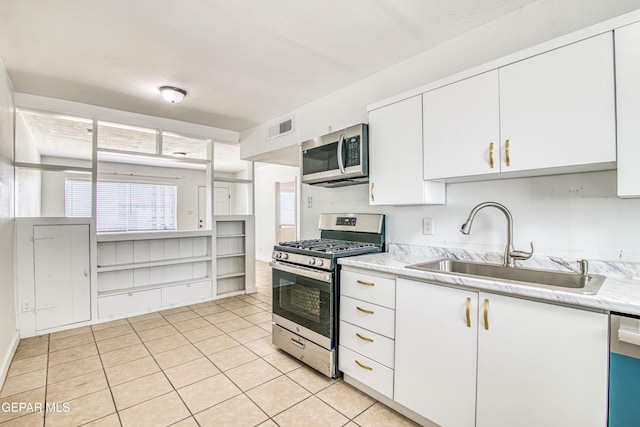 8929 Robert Dr Unit 1 & 2, El Paso, TX 79904 - kitchen with visible vents, light countertops, white cabinets, a sink, and appliances with stainless steel finishes