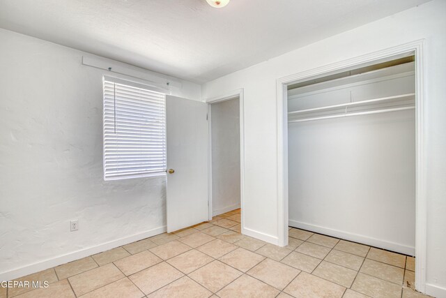 8929 Robert Dr Unit 1 & 2, El Paso, TX 79904 - unfurnished bedroom featuring light tile patterned floors, baseboards, and a closet