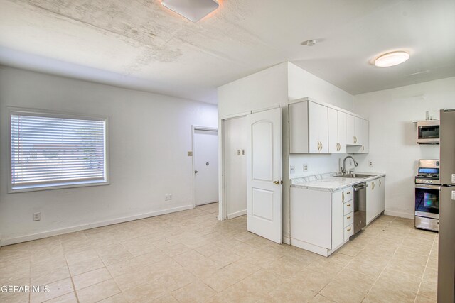 8929 Robert Dr Unit 1 & 2, El Paso, TX 79904 - kitchen with light tile patterned flooring, baseboards, white cabinetry, a sink, and appliances with stainless steel finishes