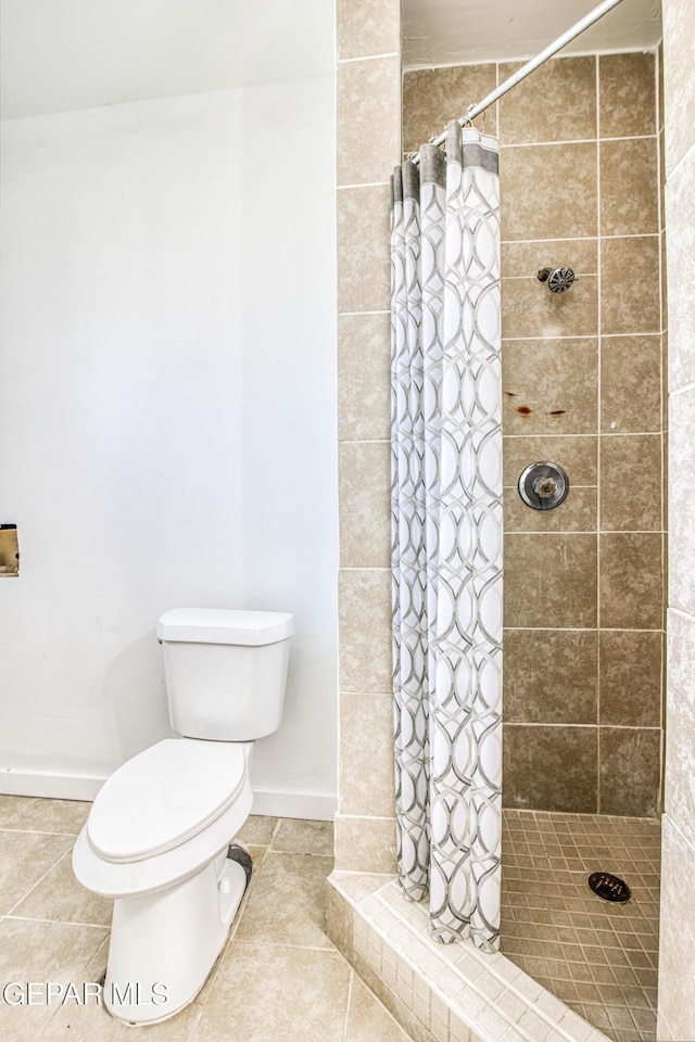 8929 Robert Dr Unit 1 & 2, El Paso, TX 79904 - bathroom featuring baseboards, tile patterned flooring, a shower stall, and toilet