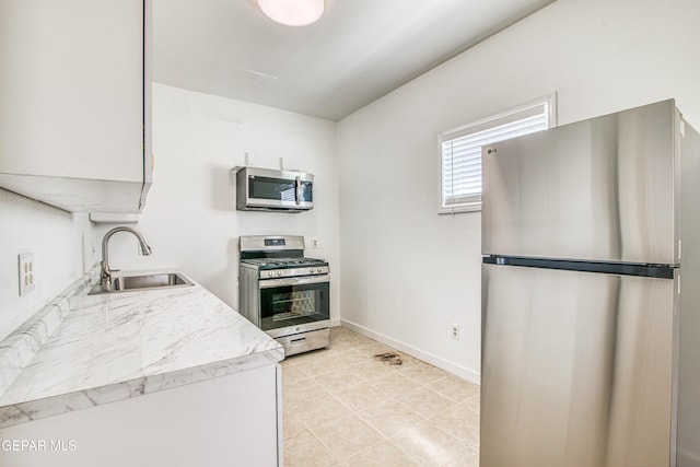 8929 Robert Dr Unit 1 & 2, El Paso, TX 79904 - kitchen with appliances with stainless steel finishes, a sink, baseboards, light countertops, and light tile patterned flooring