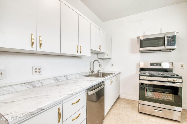 8929 Robert Dr Unit 1 & 2, El Paso, TX 79904 - kitchen with white cabinets, light stone countertops, appliances with stainless steel finishes, a sink, and baseboards