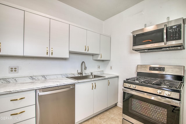 8929 Robert Dr Unit 1 & 2, El Paso, TX 79904 - kitchen featuring light stone countertops, white cabinets, a sink, appliances with stainless steel finishes, and light tile patterned floors