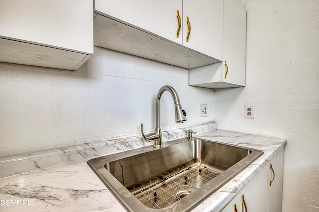 8929 Robert Dr Unit 1 & 2, El Paso, TX 79904 - kitchen featuring a sink, light stone counters, and white cabinetry