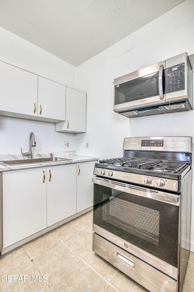 8929 Robert Dr Unit 1 & 2, El Paso, TX 79904 - kitchen featuring light countertops, stainless steel appliances, white cabinetry, and a sink