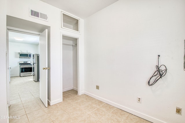 8929 Robert Dr Unit 1 & 2, El Paso, TX 79904 - unfurnished bedroom with visible vents, freestanding refrigerator, baseboards, and light tile patterned floors